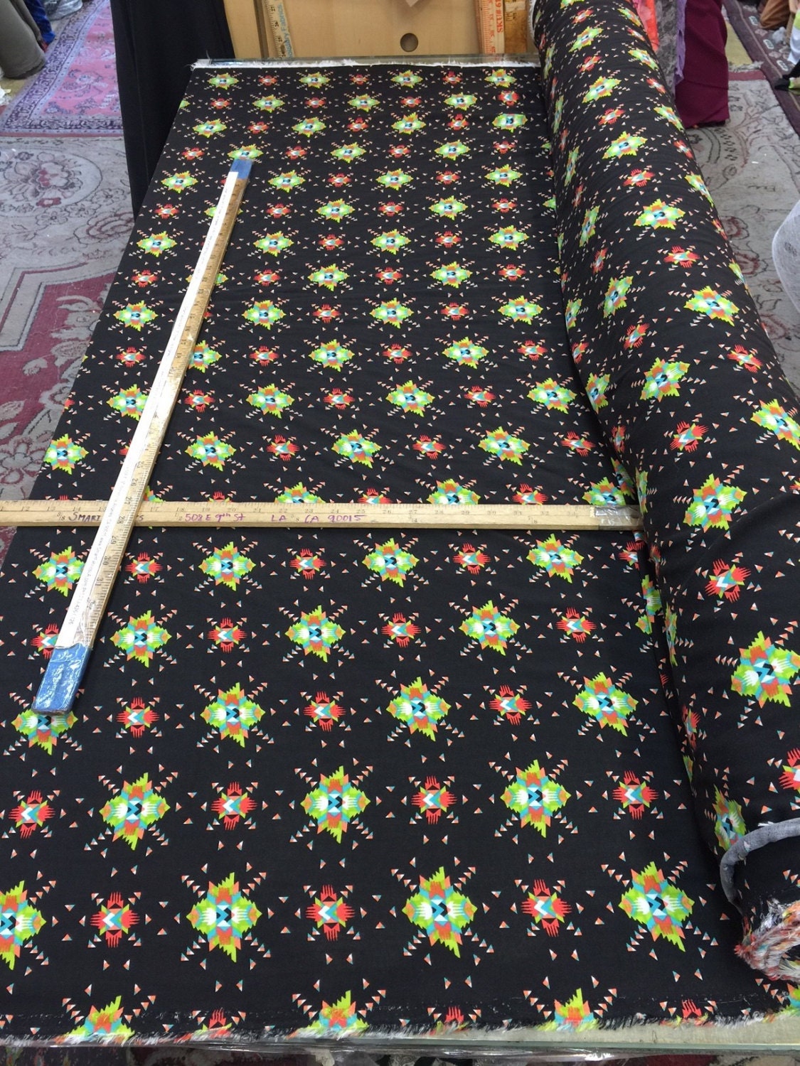 100% rayon challis. Black Native American inspired print. Fabric sold By the yard black green orange